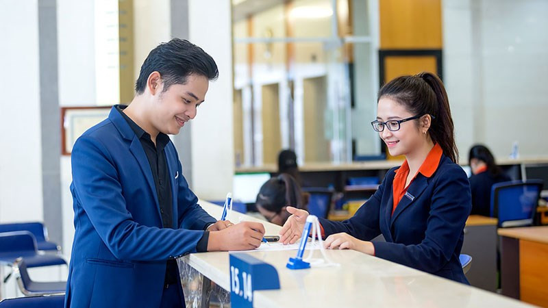 alt: Giao dịch viên Sacombank đang hỗ trợ khách hàng