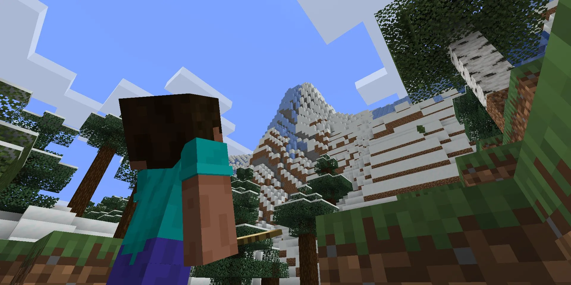 Hình ảnh game Minecraft, với nhân vật Steve đang nhìn lên một vách đá lớn