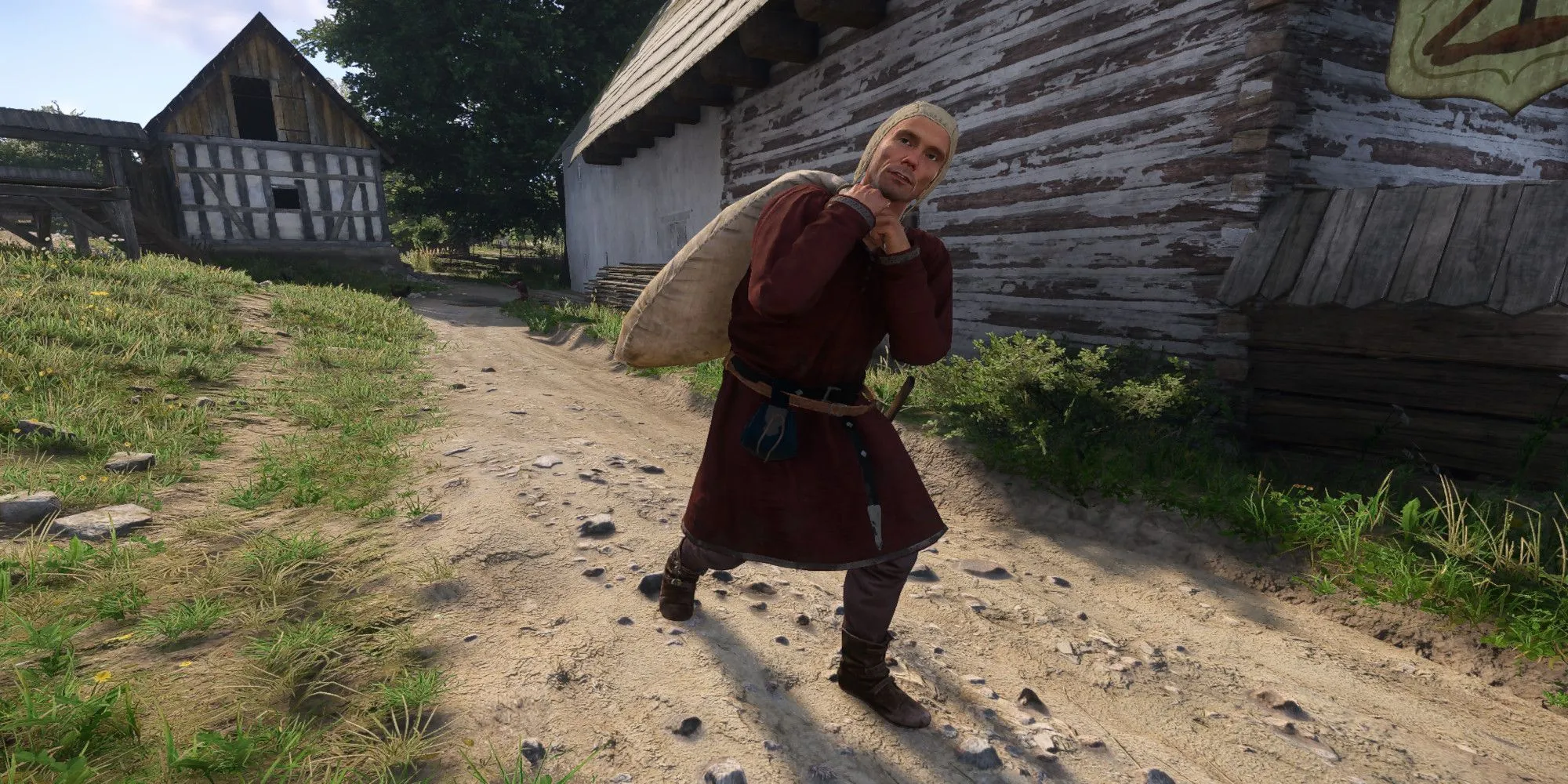 Nhân vật vác bao tải nặng trong Kingdom Come: Deliverance 2, liên quan đến việc vận chuyển đồ vật (có thể là đồ ăn trộm) trong game nhập vai trung cổ.