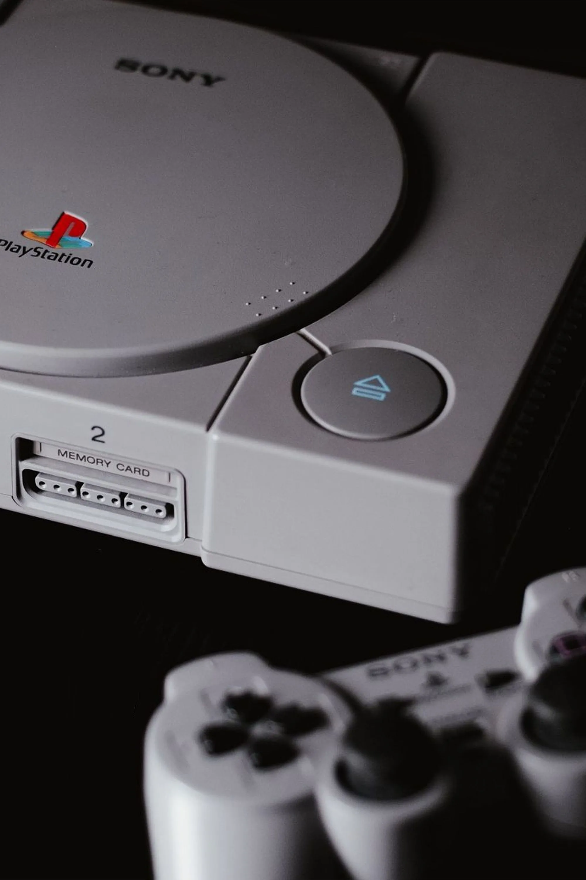 Máy chơi game console PlayStation 1 nguyên bản và tay cầm DualShock biểu tượng